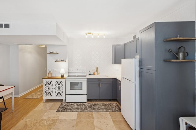 260 E Chestnut St Unit 1706, Chicago, IL 60611 - kitchen featuring white appliances, a sink, open shelves, gray cabinetry, and light countertops