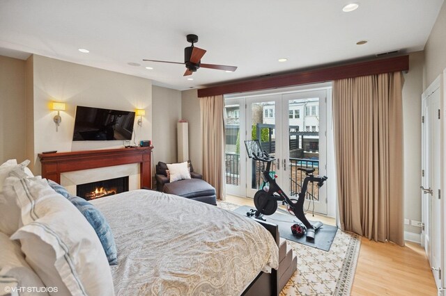 1442 W Cuyler Ave, Chicago, IL 60613 - bedroom with french doors, light wood-style floors, access to outside, a warm lit fireplace, and recessed lighting