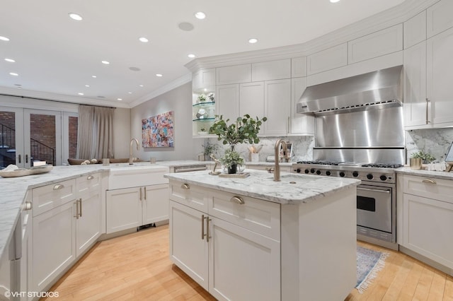 1442 W Cuyler Ave, Chicago, IL 60613 - kitchen featuring a sink, ornamental molding, wall chimney exhaust hood, high end range, and light wood-style floors