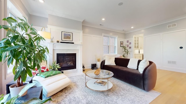 living room featuring wood finished floors, a high end fireplace, recessed lighting, and crown molding