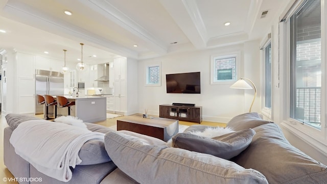 living area with baseboards, ornamental molding, light wood-style floors, and recessed lighting