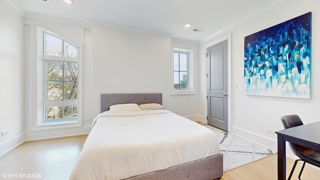 bedroom featuring multiple windows, wood finished floors, baseboards, crown molding, and recessed lighting