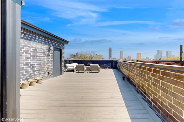 wooden terrace with an outdoor hangout area and a view of skyline