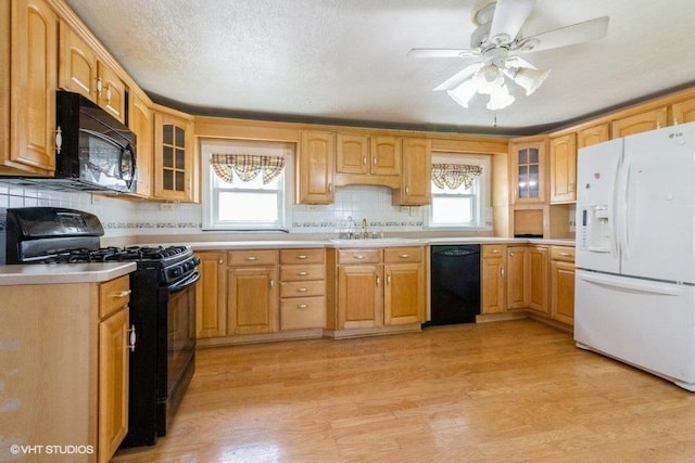 1027 Paul St, Ottawa, IL 61350 - kitchen featuring black appliances, healthy amount of natural light, a sink, and glass insert cabinets