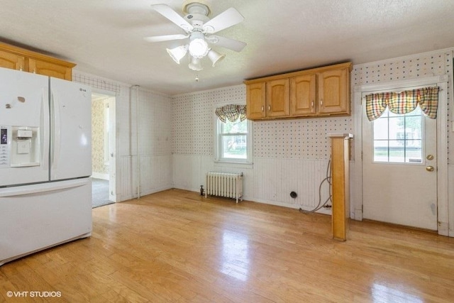 1027 Paul St, Ottawa, IL 61350 - kitchen featuring white refrigerator with ice dispenser, radiator heating unit, wallpapered walls, healthy amount of natural light, and light wood finished floors