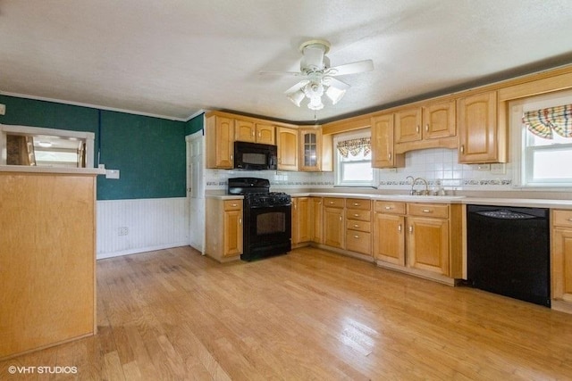 1027 Paul St, Ottawa, IL 61350 - kitchen featuring black appliances, wainscoting, light wood finished floors, light countertops, and ceiling fan