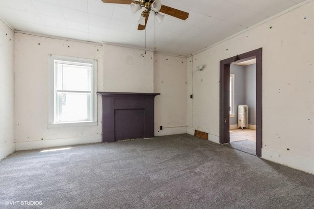 1027 Paul St, Ottawa, IL 61350 - unfurnished living room featuring radiator, carpet flooring, ceiling fan, and a fireplace