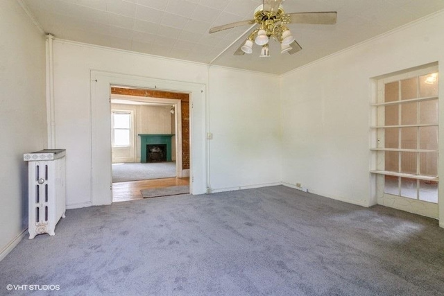 1027 Paul St, Ottawa, IL 61350 - spare room featuring carpet floors, a ceiling fan, crown molding, and a fireplace