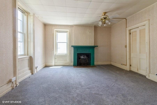 1027 Paul St, Ottawa, IL 61350 - unfurnished living room with plenty of natural light, carpet floors, a fireplace with flush hearth, ceiling fan, and crown molding