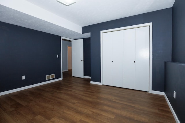 107 Regal Dr, Normal, IL 61761 - unfurnished bedroom with baseboards and dark wood-type flooring