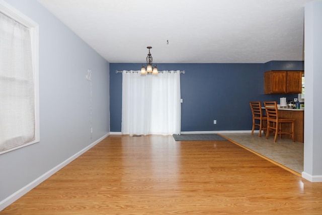 107 Regal Dr, Normal, IL 61761 - unfurnished dining area featuring a chandelier and light wood-type flooring