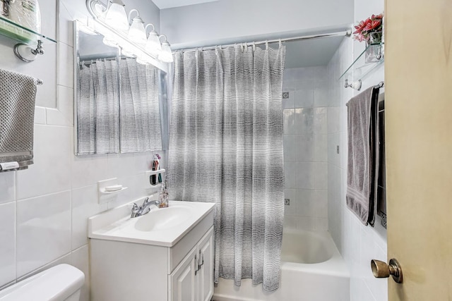 bathroom featuring toilet, tile walls, vanity, and shower / tub combo