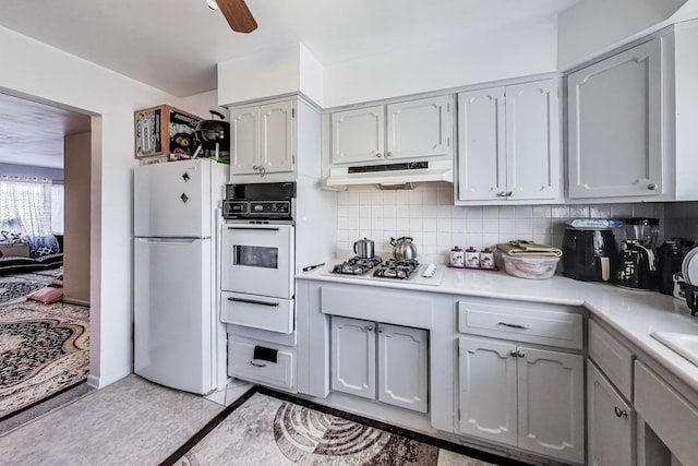 kitchen with white appliances, a warming drawer, under cabinet range hood, light countertops, and gray cabinets