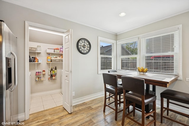 dining room with crown molding, light wood-style flooring, baseboards, and recessed lighting