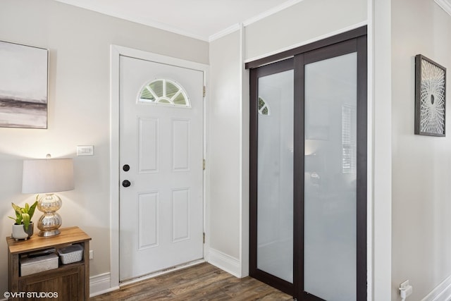 entrance foyer with crown molding, dark wood-style flooring, and baseboards