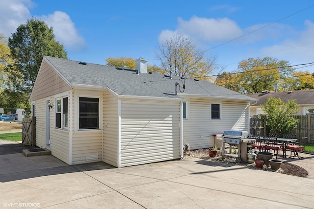 back of house with a patio, fence, roof with shingles, and a chimney