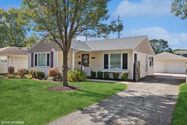 ranch-style home featuring an outdoor structure, a detached garage, a front yard, and a porch