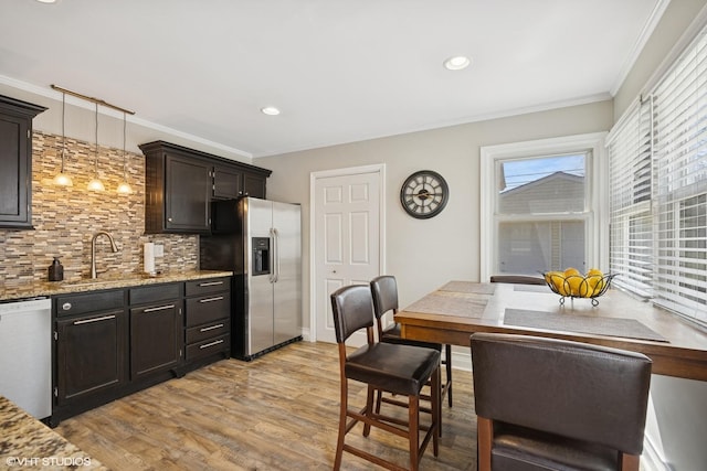 kitchen featuring stainless steel fridge, dishwashing machine, a sink, tasteful backsplash, and ornamental molding