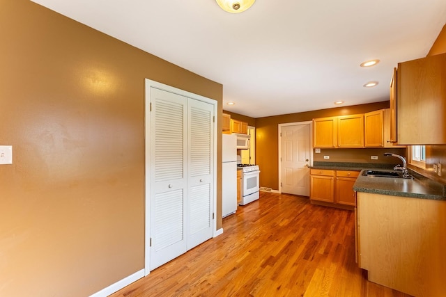 204 N Rohlwing Rd, Palatine, IL 60074 - kitchen featuring a sink, white appliances, dark countertops, wood finished floors, and recessed lighting