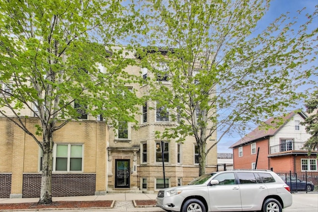 view of property with brick siding and fence