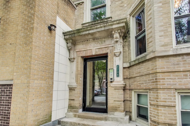 view of exterior entry with brick siding