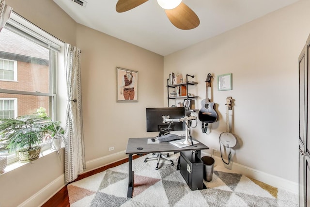 office with ceiling fan and baseboards