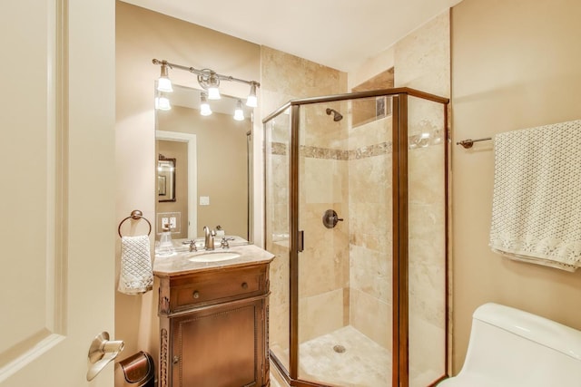full bathroom featuring a shower stall, vanity, and toilet