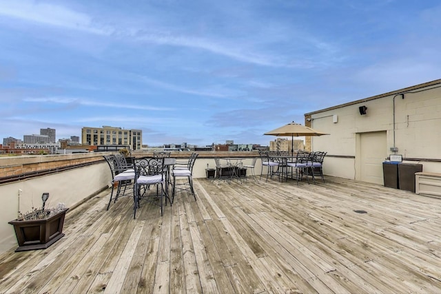 wooden deck with outdoor dining space and a view of city