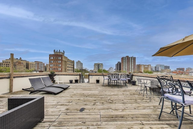 deck with a view of skyline and outdoor dining area