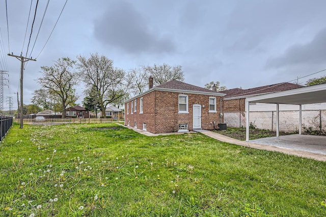 view of home's exterior with a chimney, a lawn, brick siding, fence, and central AC