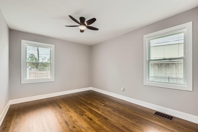 spare room with ceiling fan, baseboards, dark wood-style floors, and visible vents