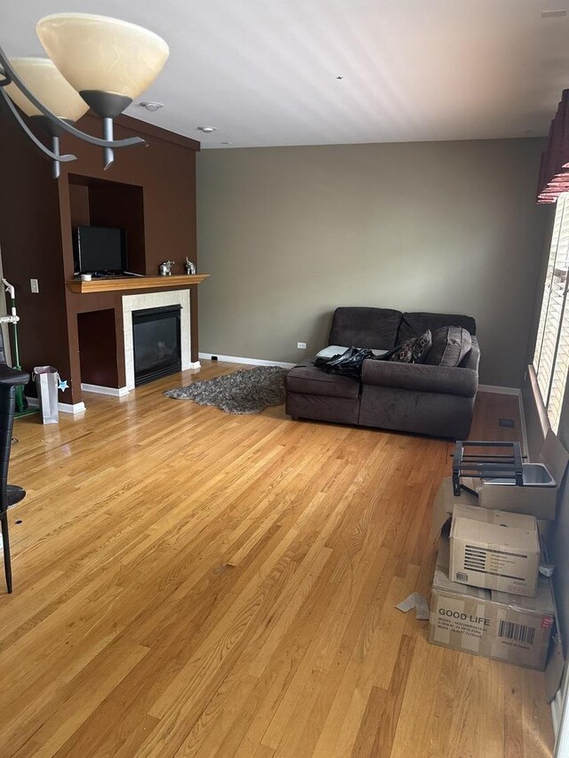 5588 Cambridge Way, Hanover Park, IL 60133 - living room featuring a glass covered fireplace, baseboards, and light wood-style flooring