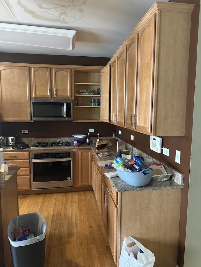 5588 Cambridge Way, Hanover Park, IL 60133 - kitchen featuring light wood-style flooring, appliances with stainless steel finishes, open shelves, and dark stone counters
