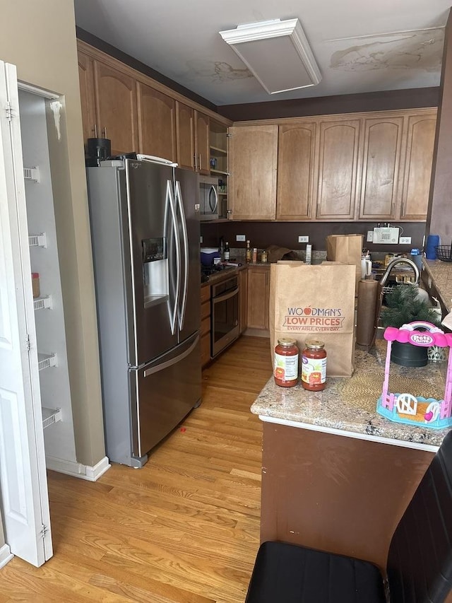 5588 Cambridge Way, Hanover Park, IL 60133 - kitchen with light stone counters, stainless steel appliances, open shelves, and light wood-style flooring