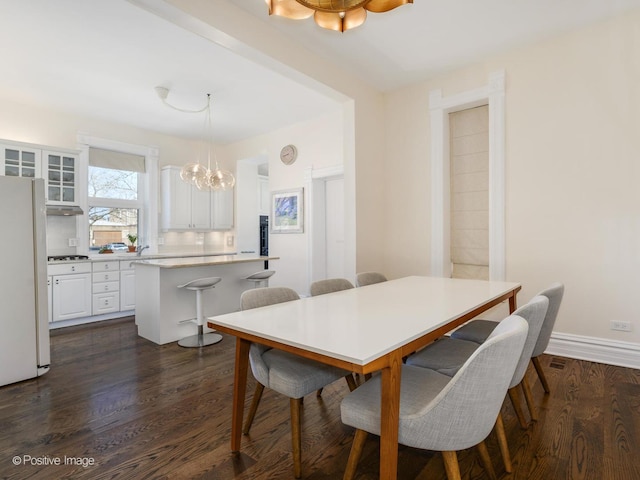 2426 W Mclean Ave, Chicago, IL 60647 - dining room featuring a chandelier, dark wood-type flooring, and baseboards
