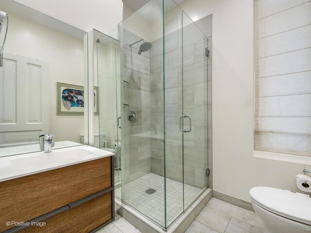 2426 W Mclean Ave, Chicago, IL 60647 - bathroom with toilet, vanity, a stall shower, and tile patterned floors