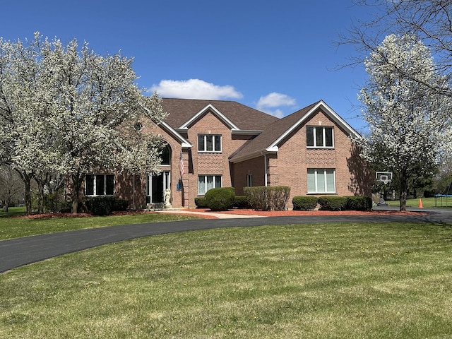 view of front of property featuring a front yard and brick siding