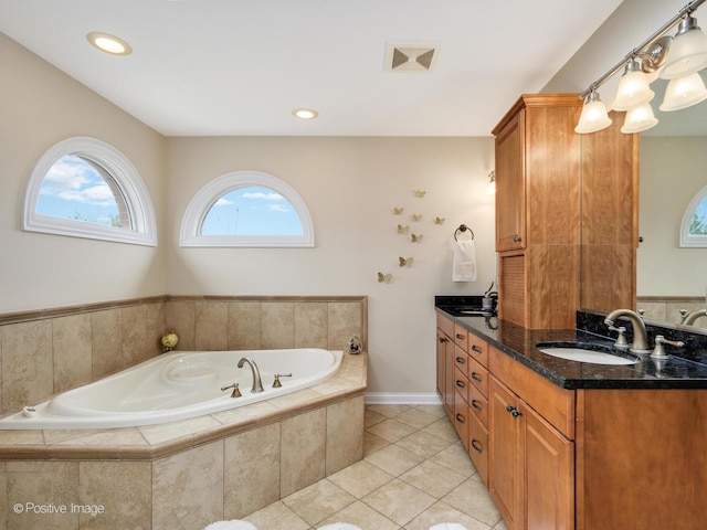 full bathroom featuring double vanity, a bath, tile patterned floors, and a sink