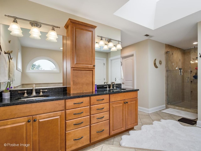 full bathroom with tile patterned floors, double vanity, a stall shower, and a sink