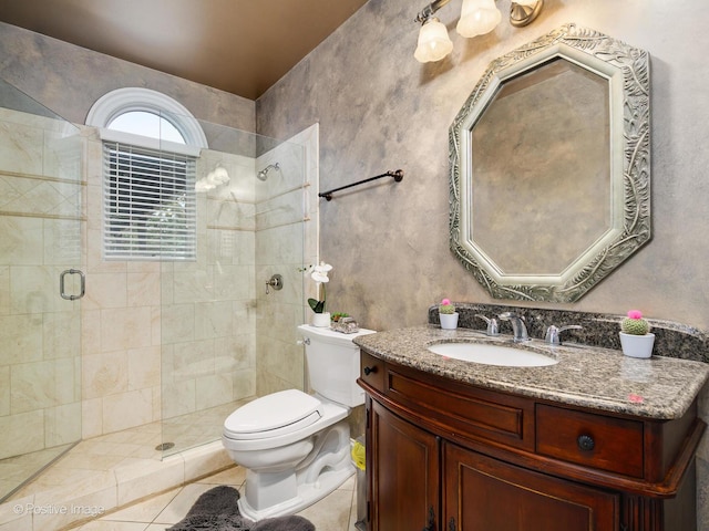 bathroom with vanity, toilet, tile patterned flooring, and a tile shower