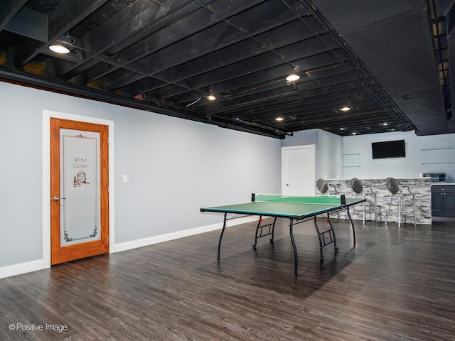 game room with baseboards, bar area, and wood finished floors