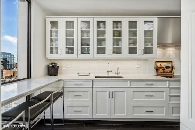 bar area with a sink and tasteful backsplash