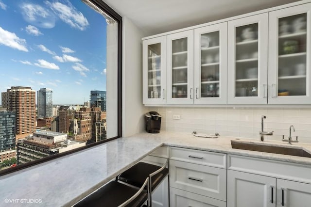 bar with a sink, backsplash, and a view of city