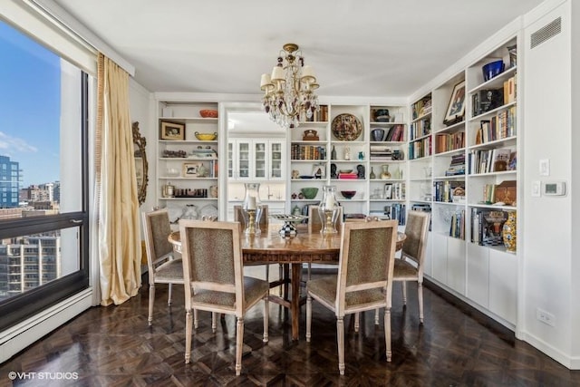 dining room featuring a chandelier, baseboard heating, and a city view