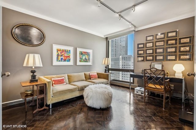 living area with track lighting, an office area, floor to ceiling windows, and baseboards