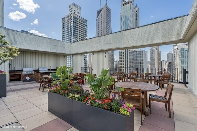 view of patio with grilling area, a skyline view, and outdoor dining area