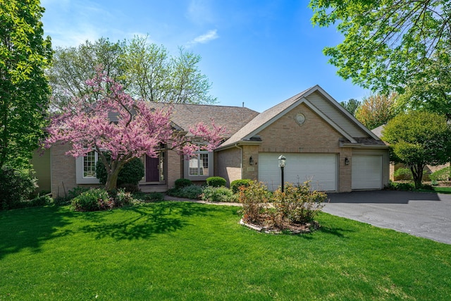 638 Roxbury Rd, Rockford, IL 61107 - view of front of property with brick siding, a garage, driveway, and a front lawn