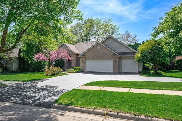 638 Roxbury Rd, Rockford, IL 61107 - view of front of home with a front yard, concrete driveway, brick siding, and a garage