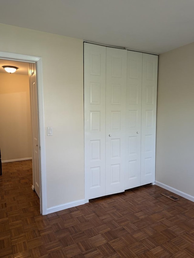 unfurnished bedroom with baseboards and a closet