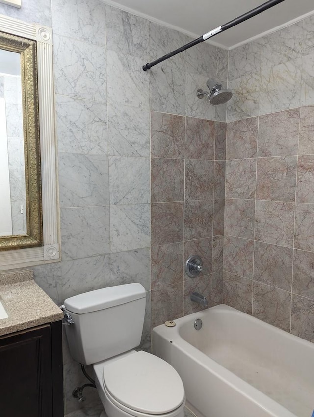 bathroom featuring tile walls, toilet, bathing tub / shower combination, and vanity